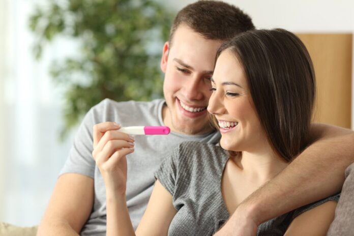 A couple happily looking at pregnancy test kit