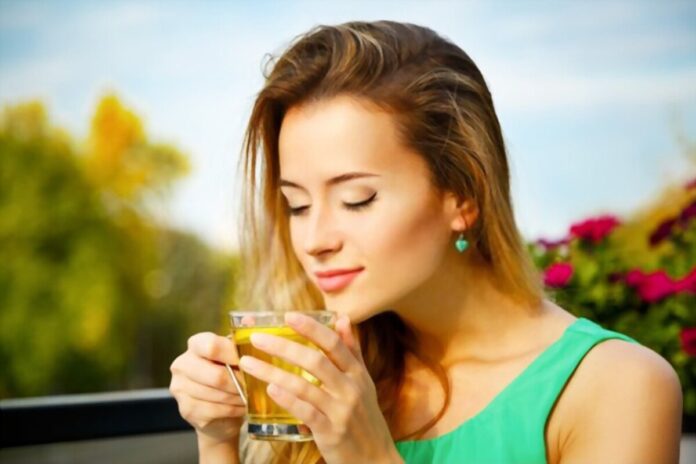 A young lady is drinking green tea for its health benefits.