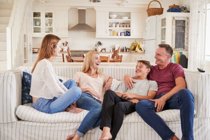 Family With Teenage Children Relaxing Together On Sofa