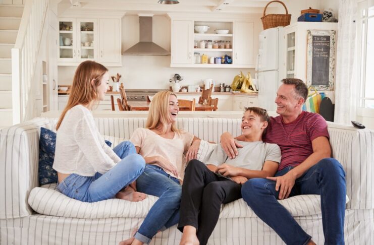 Family With Teenage Children Relaxing Together On Sofa
